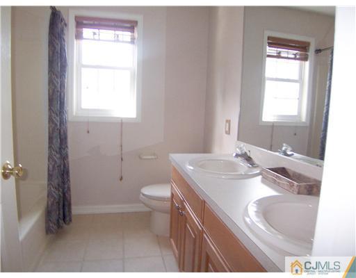 34 West Hill Road Colonia, NJ 07067 - Photo 17 of 25 a bathroom with a granite countertop sink a toilet and a window