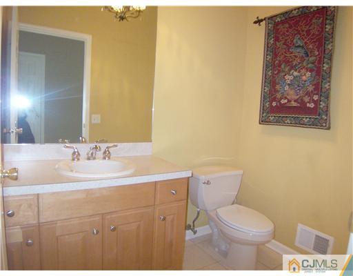 34 West Hill Road Colonia, NJ 07067 - Photo 18 of 25 a bathroom with a toilet a sink and mirror