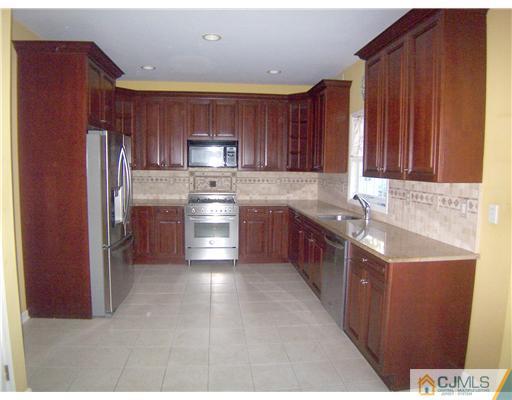 34 West Hill Road Colonia, NJ 07067 - Photo 3 of 25 a large kitchen with stainless steel appliances granite countertop a sink stove refrigerator and cabinets