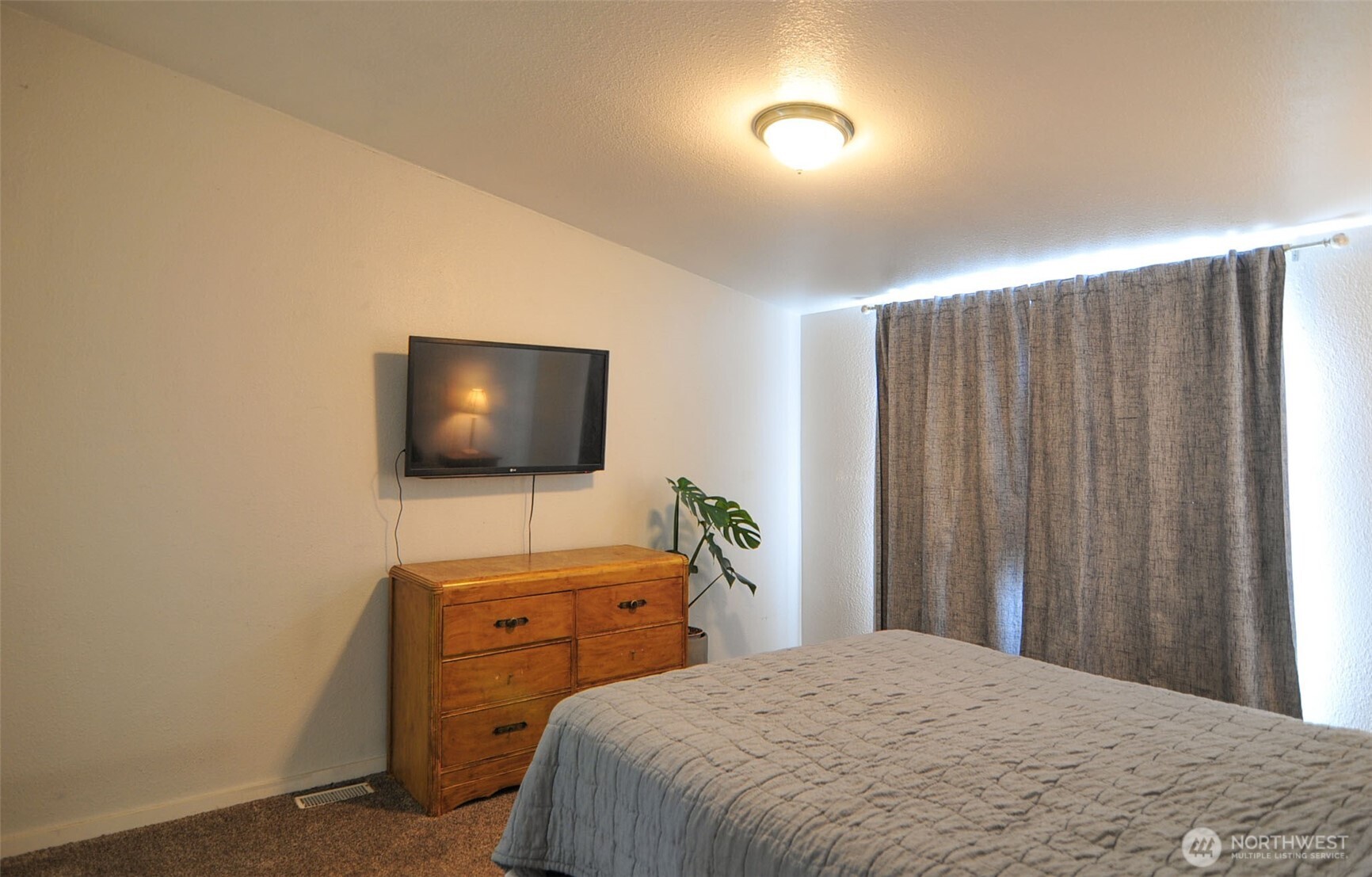 1698 Sunset Drive Wenatchee, WA 98801 - Photo 9 of 22 a bedroom with a bed and a flat screen tv