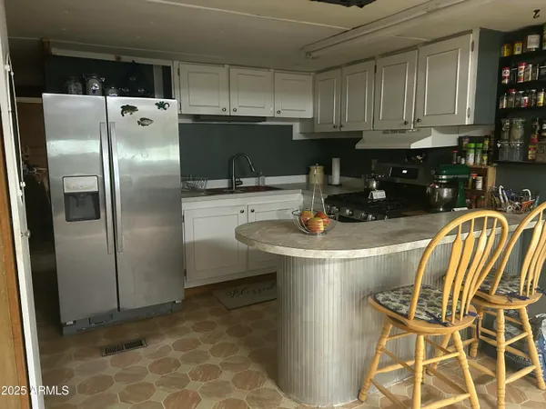 a kitchen with stainless steel appliances granite countertop a refrigerator a stove a sink and a stove