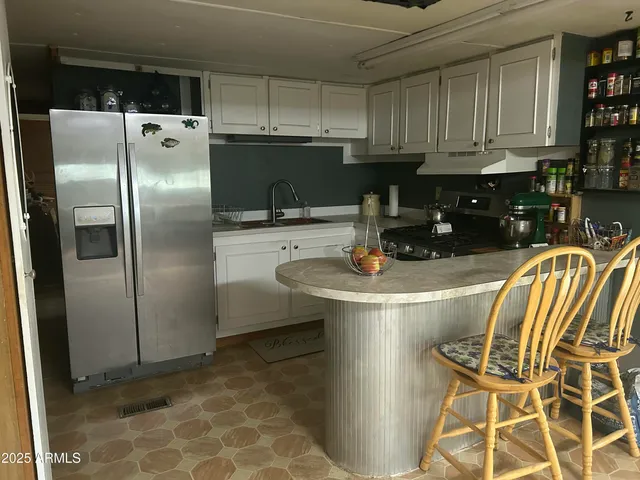 a kitchen with stainless steel appliances granite countertop a refrigerator a stove a sink and a stove