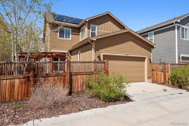 a view of a blue house with a yard and large tree