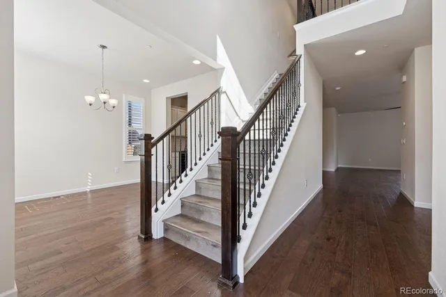 a view of a hallway with wooden floor and stairs