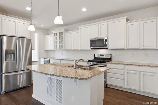 a kitchen with stainless steel appliances granite countertop a sink stove and refrigerator