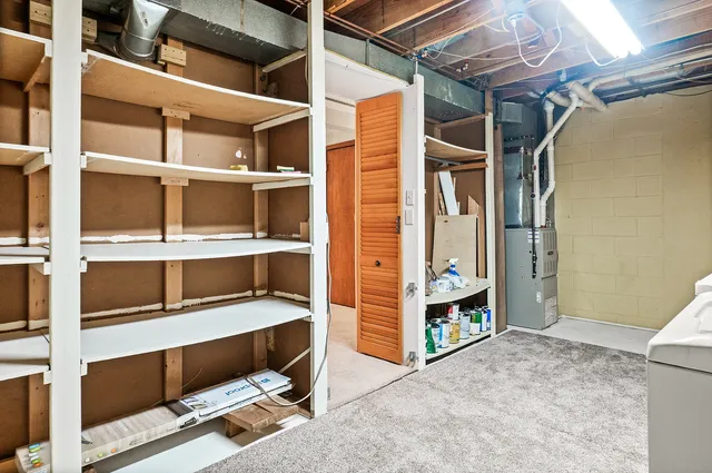 a view of an empty room with cabinet and mirrors