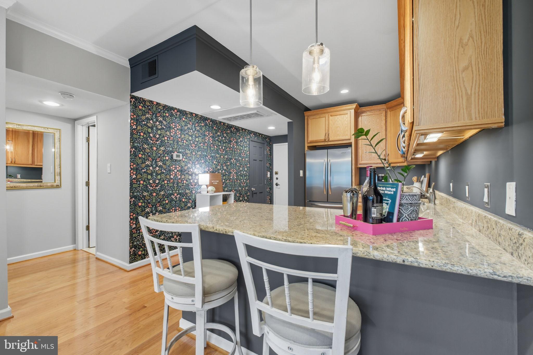 1669 Columbia Road Northwest, Unit 203 Washington, DC 20009 - Photo 3 of 18 a kitchen with granite countertop kitchen island stainless steel appliances a dining table and chairs