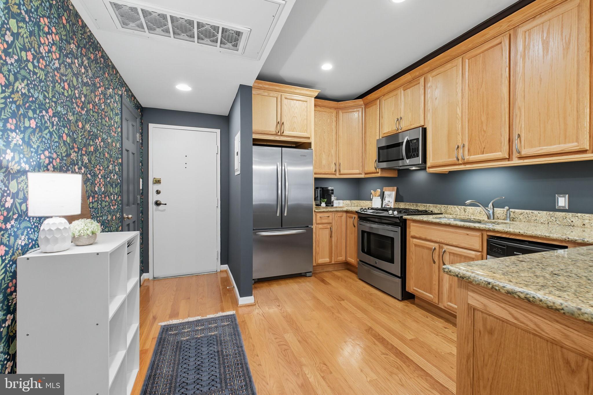 1669 Columbia Road Northwest, Unit 203 Washington, DC 20009 - Photo 4 of 18 a kitchen with stainless steel appliances granite countertop a refrigerator a stove top oven a sink and dishwasher