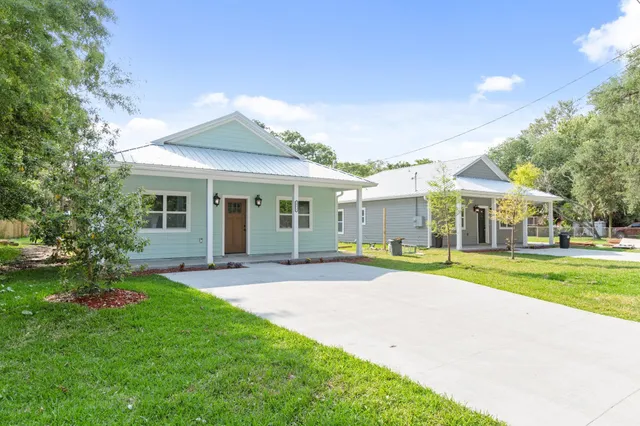 a view of a house with a yard and porch