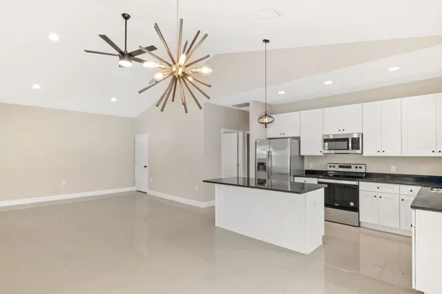 a kitchen with stainless steel appliances kitchen island a stove a sink a center island a stove and cabinets