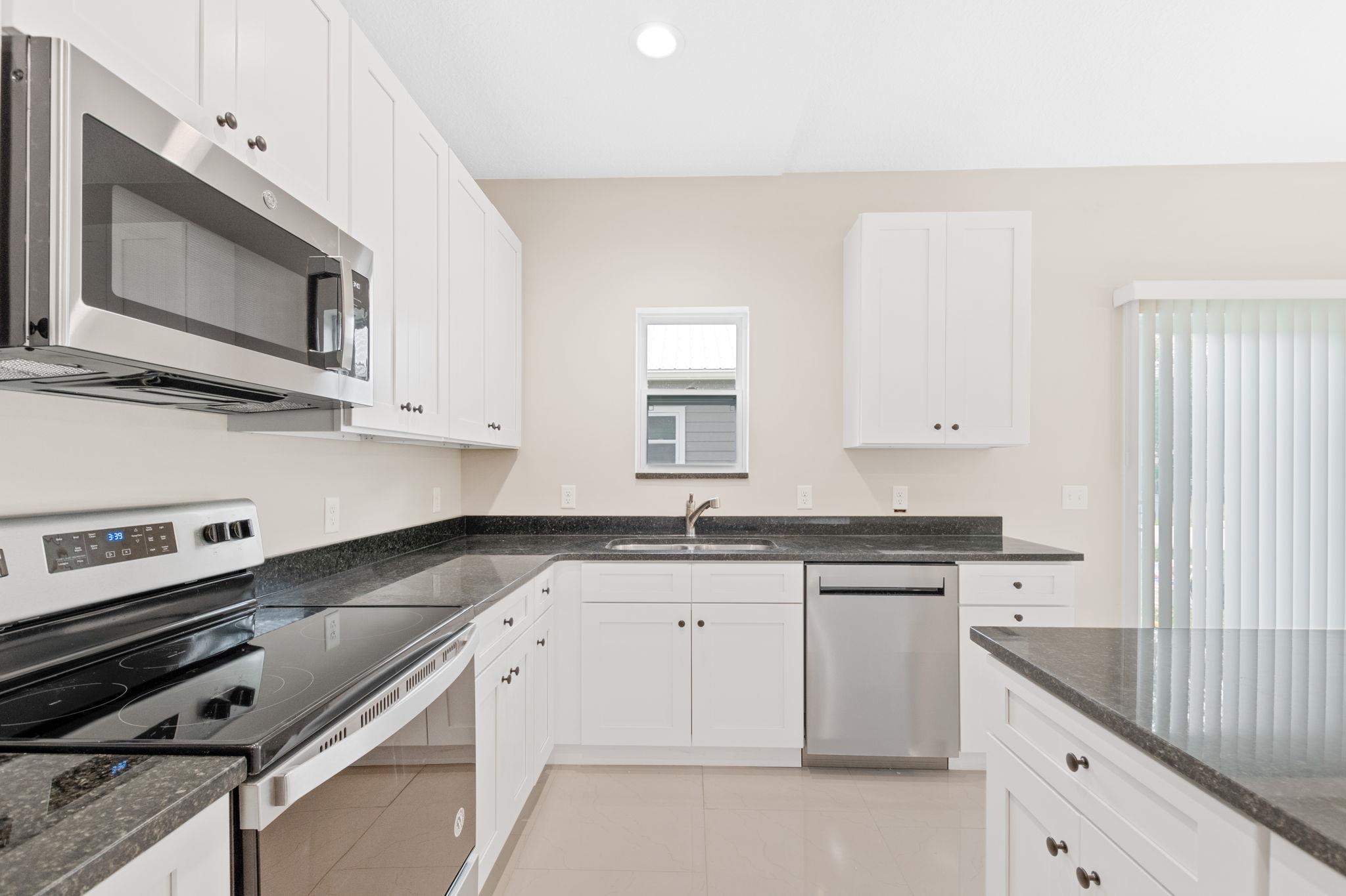 2770 Schaller Road St. Augustine, FL 32084 - Photo 14 of 29 a kitchen with granite countertop a stove sink and microwave