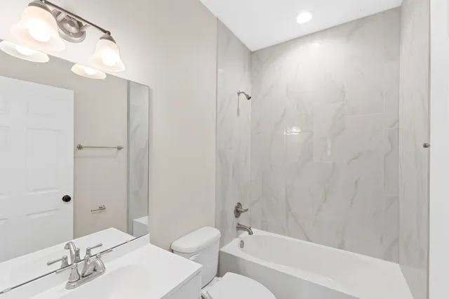 a bathroom with a bathtub a sink a toilet and a mirror