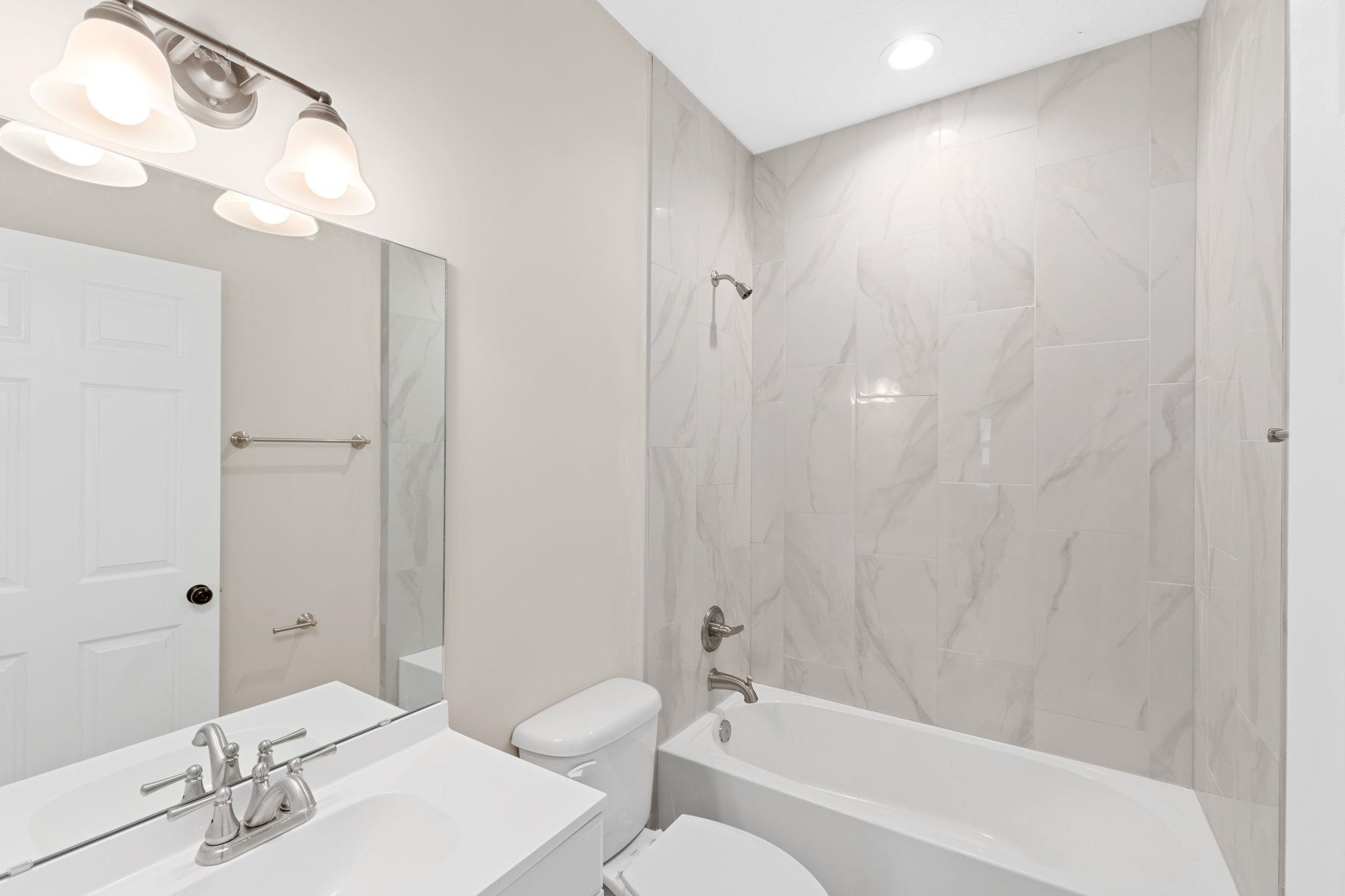 2770 Schaller Road St. Augustine, FL 32084 - Photo 16 of 29 a bathroom with a bathtub a sink a toilet and a mirror