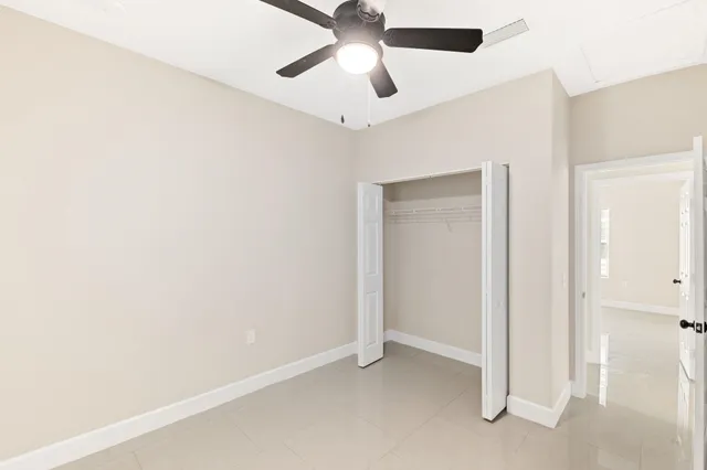 an empty room with a window and a fan