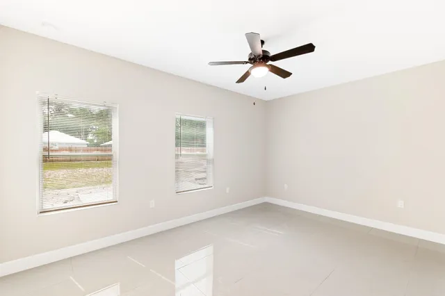 an empty room with closet and ceiling fan