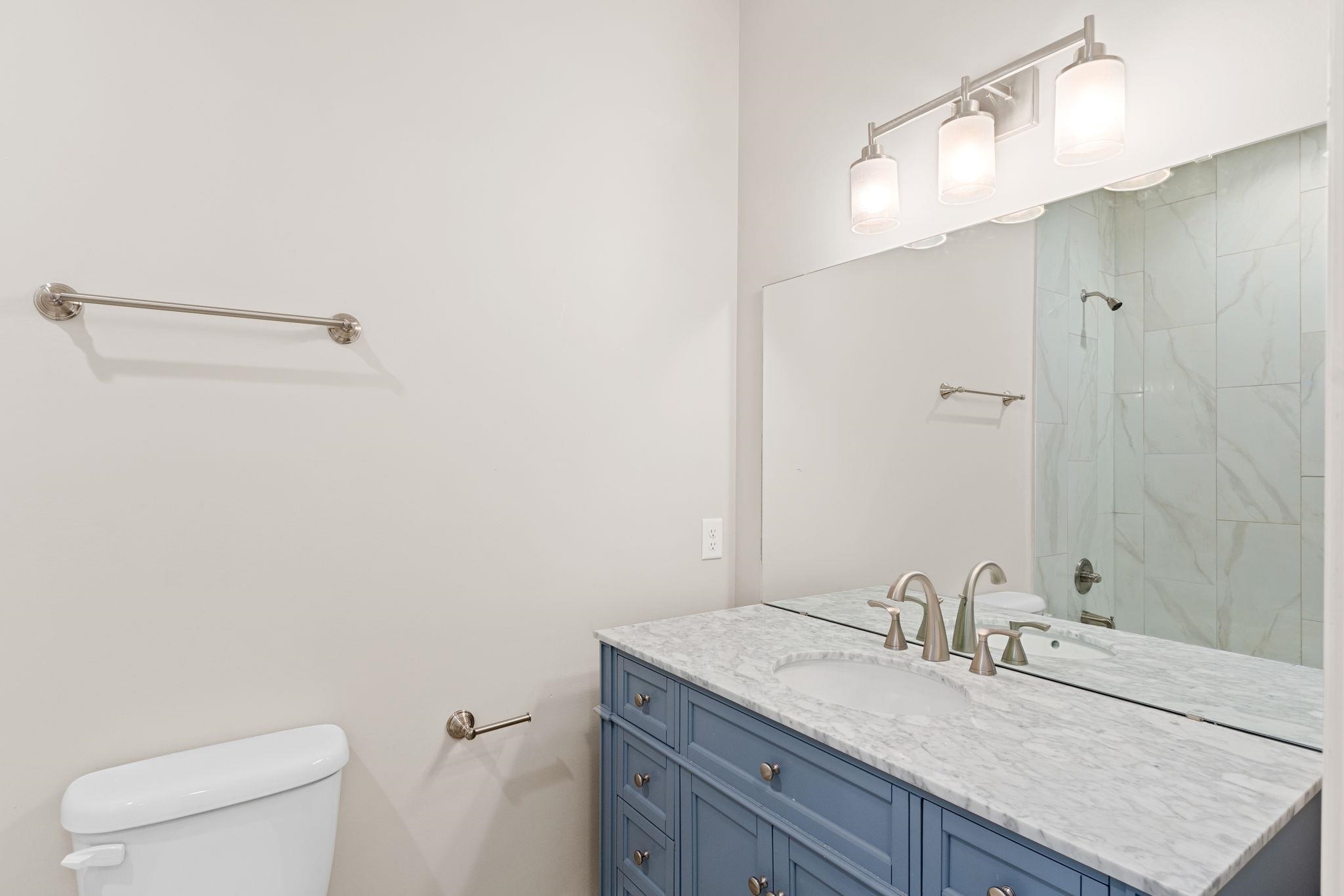 2770 Schaller Road St. Augustine, FL 32084 - Photo 26 of 29 a bathroom with a granite countertop sink a toilet and a mirror