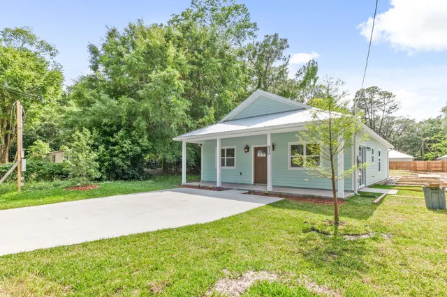 a view of a house with a yard and tree s