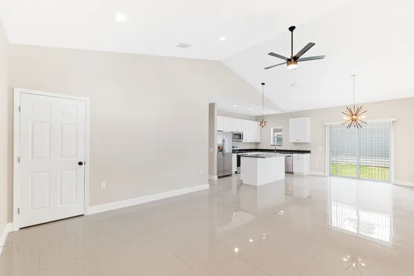 a view of a kitchen with kitchen island a counter top space appliances and cabinets