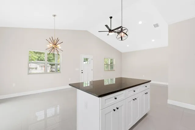 a kitchen with stainless steel appliances granite countertop a sink a window and a refrigerator