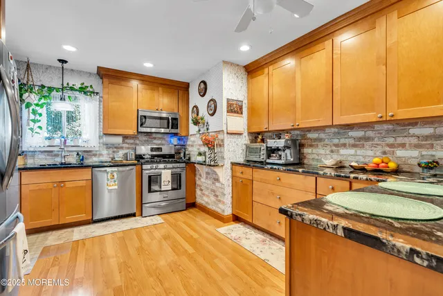 a kitchen with stainless steel appliances granite countertop sink stove top oven and cabinets