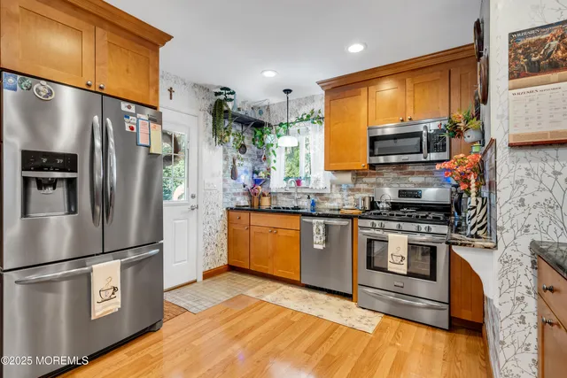 a kitchen with stainless steel appliances granite countertop a refrigerator a stove top oven a sink and dishwasher