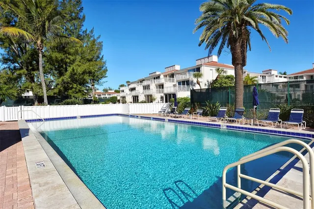 a view of a patio with table and chairs and potted plants with large tree