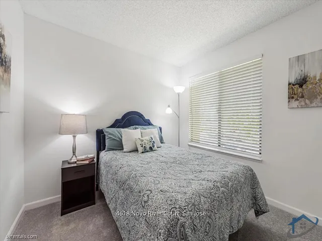 a bedroom with a bed and a lamp