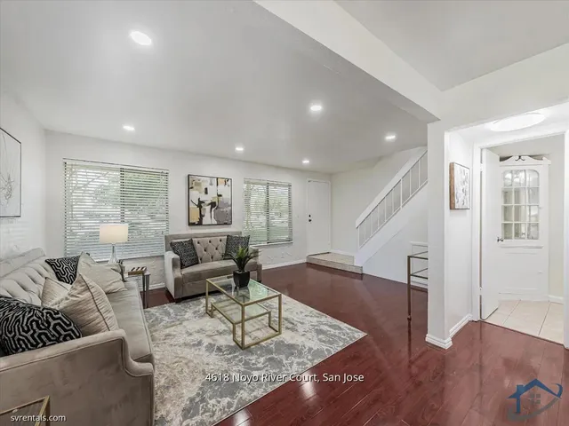 a living room with furniture rug and wooden floor