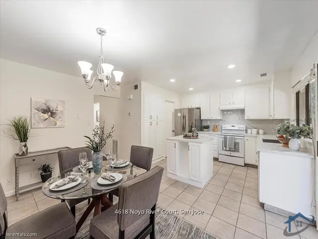 a room with stainless steel appliances kitchen island a table and chairs in it