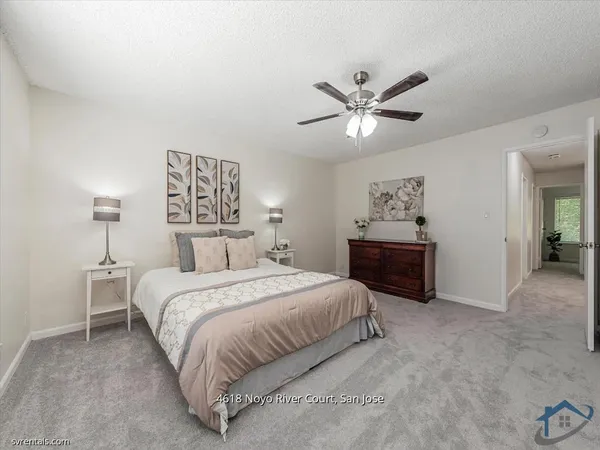 a spacious bedroom with a bed and a chandelier