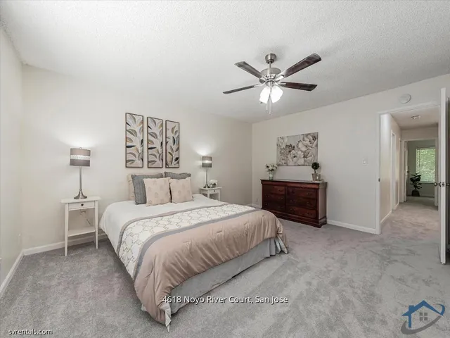 a spacious bedroom with a bed and a chandelier
