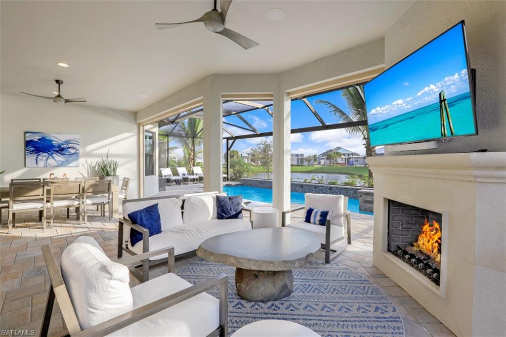 3258 Belon Lane Naples, FL 34114 - Photo 1 of 35 a living room with furniture a fireplace and a floor to ceiling window