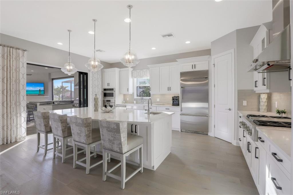 3258 Belon Lane Naples, FL 34114 - Photo 11 of 35 a kitchen with kitchen island granite countertop a table and chairs in it