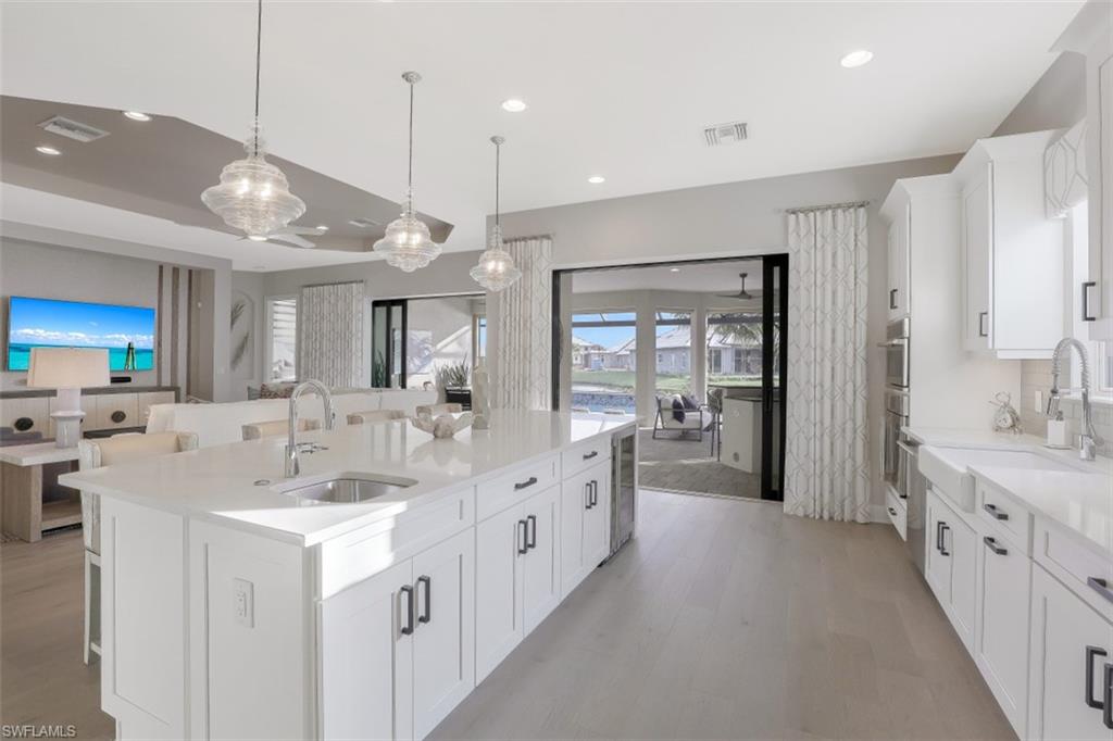 3258 Belon Lane Naples, FL 34114 - Photo 12 of 35 a large white kitchen with a large window a sink and a stove