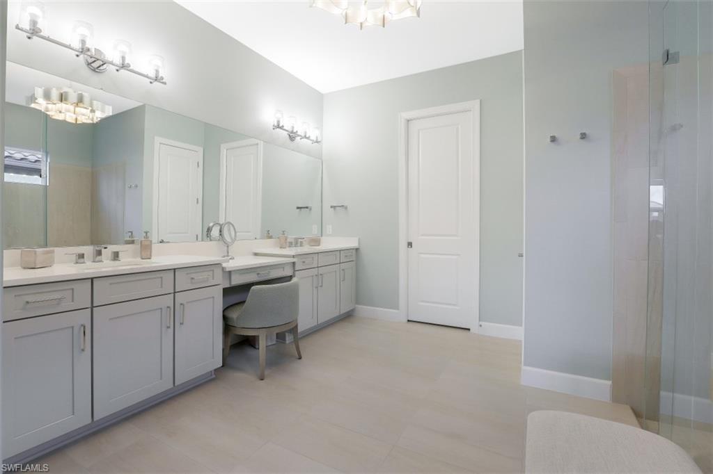 3258 Belon Lane Naples, FL 34114 - Photo 21 of 35 a bathroom with a double vanity sink mirror and toilet