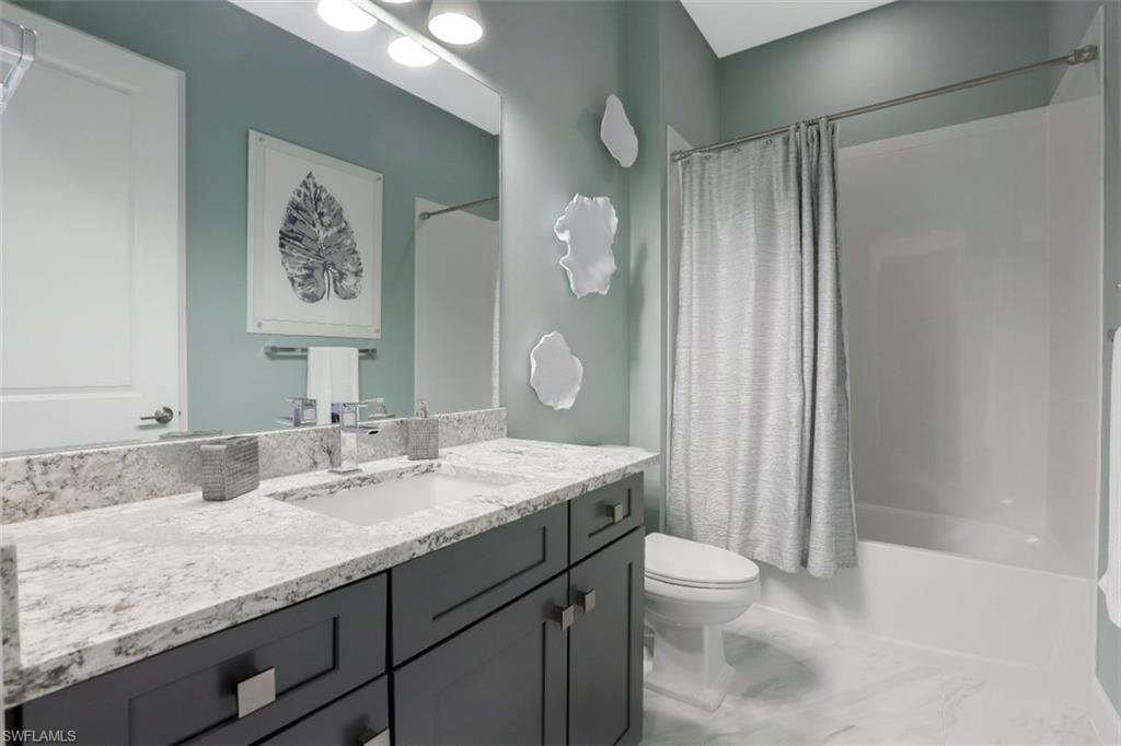 3258 Belon Lane Naples, FL 34114 - Photo 24 of 35 a bathroom with a granite countertop sink toilet and shower
