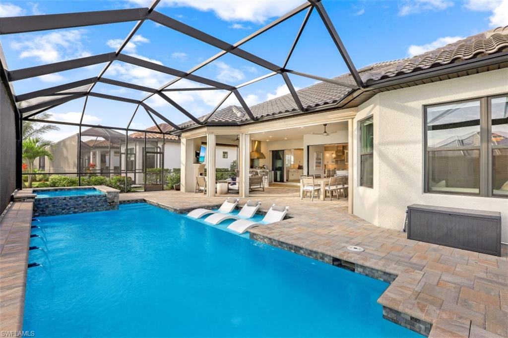 3258 Belon Lane Naples, FL 34114 - Photo 29 of 35 a view of a patio with table and chairs under an umbrella