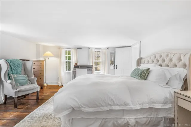 a spacious bedroom with a bed a couch and a window