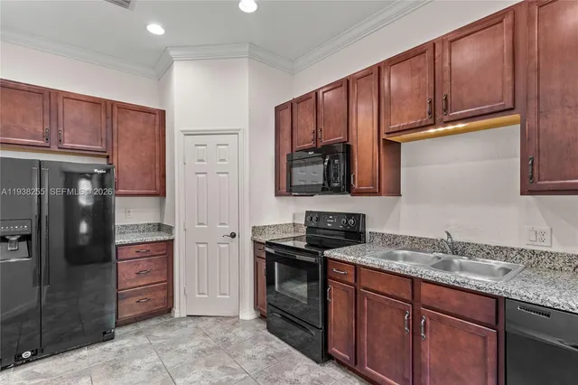a kitchen with stainless steel appliances granite countertop a refrigerator and a sink