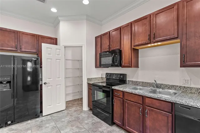 a kitchen with stainless steel appliances granite countertop a refrigerator and a sink