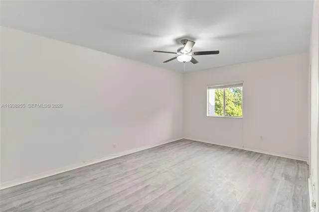 an empty room with a window and a fan