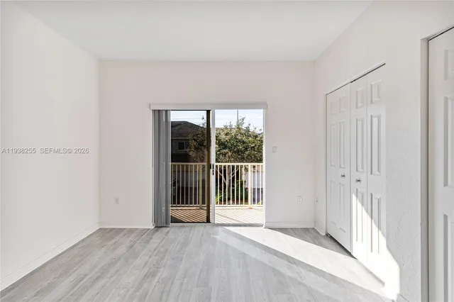 a view of a room with wooden floor and a window