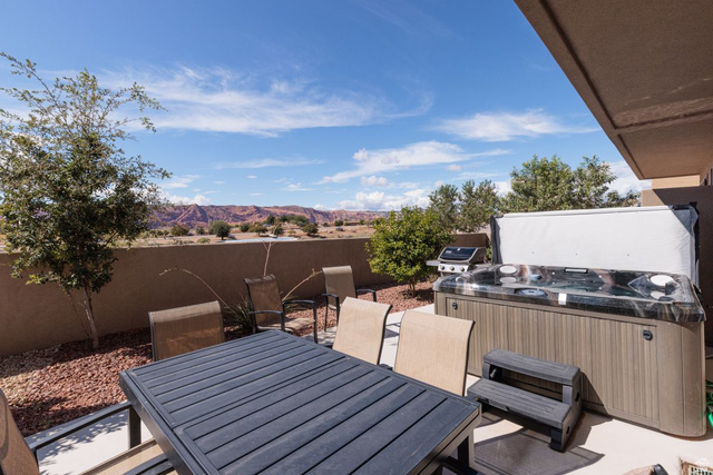 4845 Fishers Is Way St. George, UT 84770 - Photo 29 of 41 Fenced backyard with outdoor dining space, a patio, a hot tub, a mountain view, and a grill