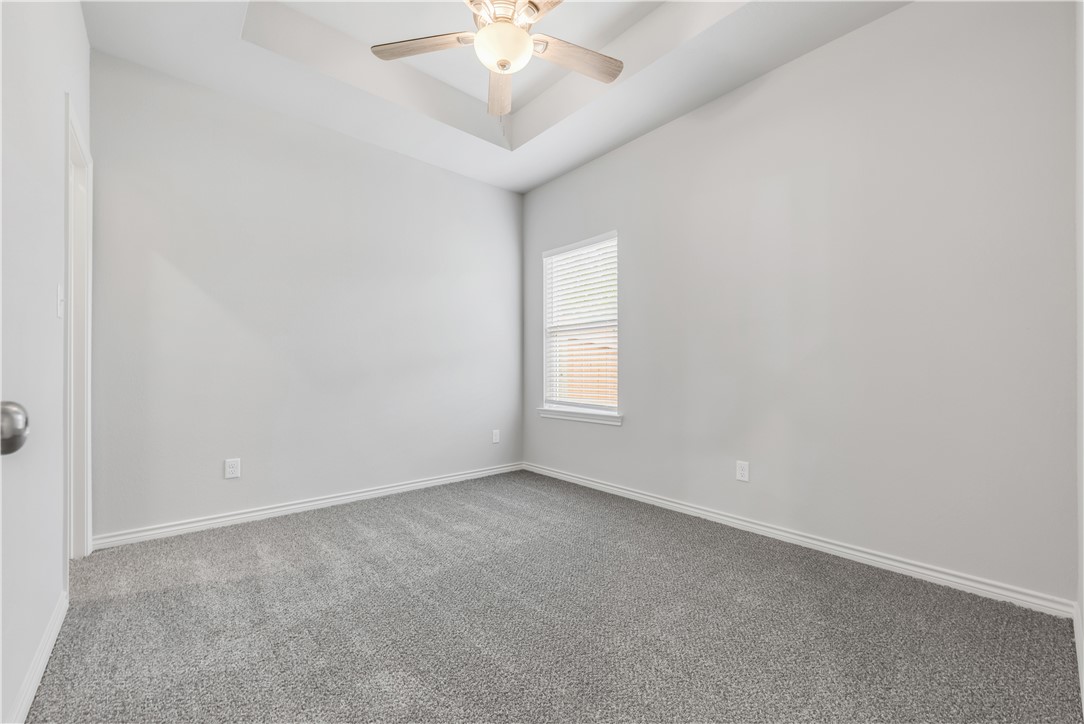 1805 Pin Oak Street Bryan, TX 77803 - Photo 15 of 20 Empty room with carpet flooring, ceiling fan, and a tray ceiling