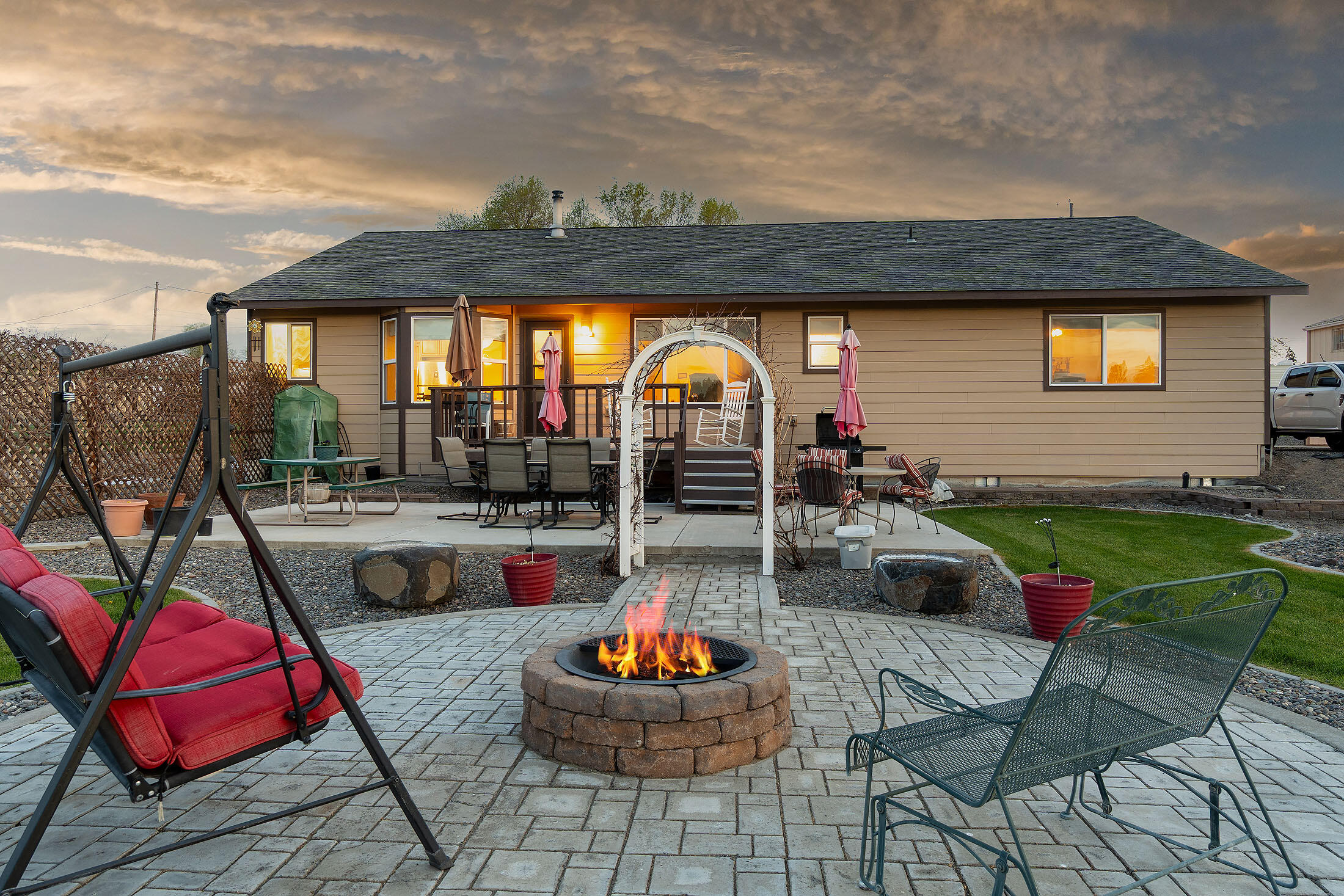 411 Northwest Mc Donald Road Prineville, OR 97754 - Photo 38 of 47 Large rear decking, extends to concrete patio, then to a paver block patio with fire pit. Don't miss the owner provided photo of the arbor with grapevines taken during the summer months.