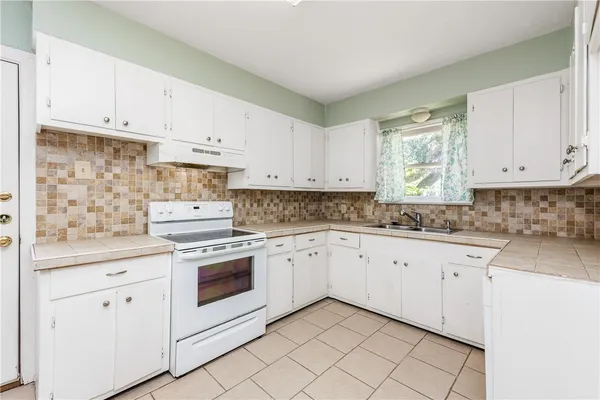 a kitchen with white cabinets stainless steel appliances and sink