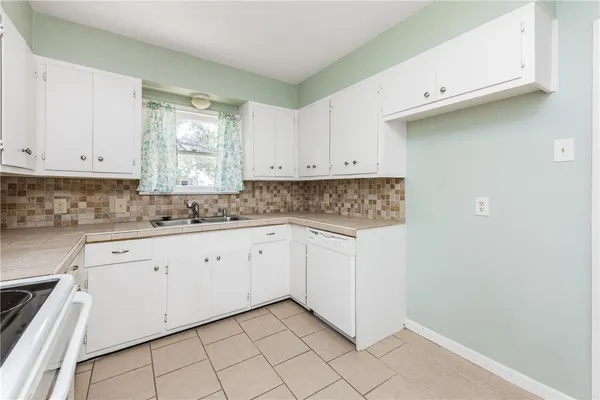 a kitchen with granite countertop white cabinets and stainless steel appliances