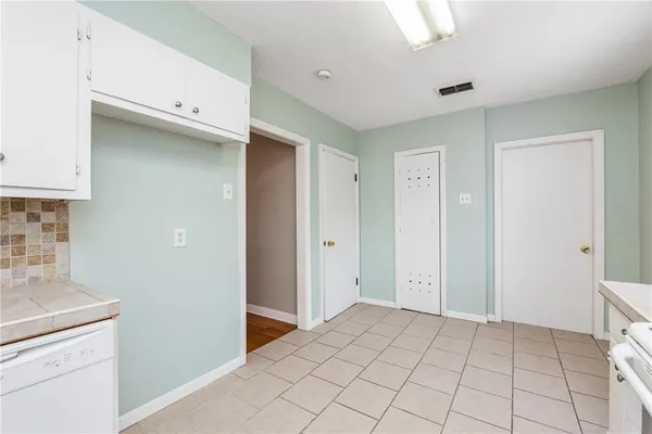 a view of a kitchen with white cabinets