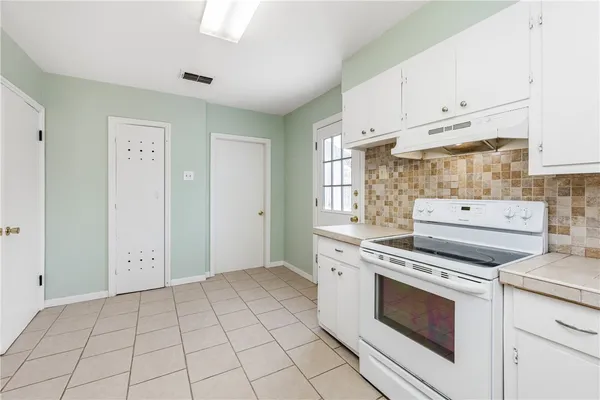 a kitchen with white cabinets and white appliances