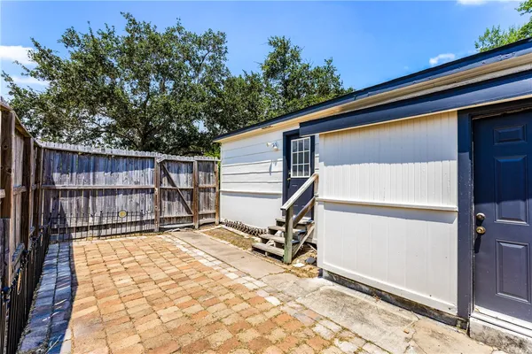 a view of backyard with wooden fence and trees